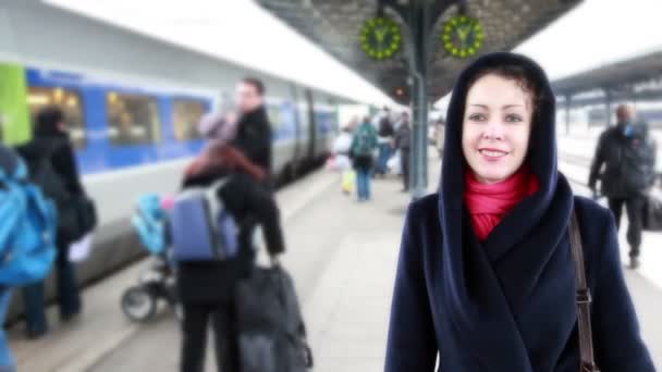 Mujer se encuentra en la estación de tren, buscando entre los huéspedes — Vídeos de Stock