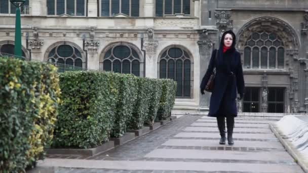 Woman goes on square from ancient cathedral — Stock Video