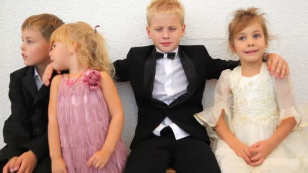 Vier kinderen in feestelijke kleding zitten in kamer — Stockvideo