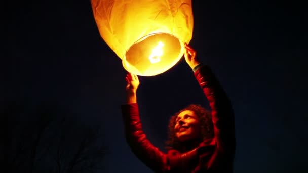 Woman holds above head glowing chinese lantern — Wideo stockowe