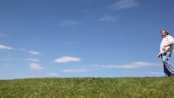 Mature couple goes lively talking by grass — Stock Video