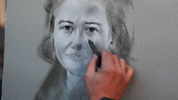 Street painter draws charcoal on canvas portrait of girl — Stock Video