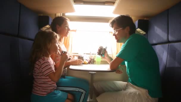 Family drinks tea in train. — Stock Video