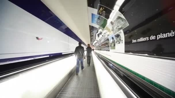 La gente pasará rápidamente por el corredor de escaleras mecánicas en el aeropuerto — Vídeo de stock