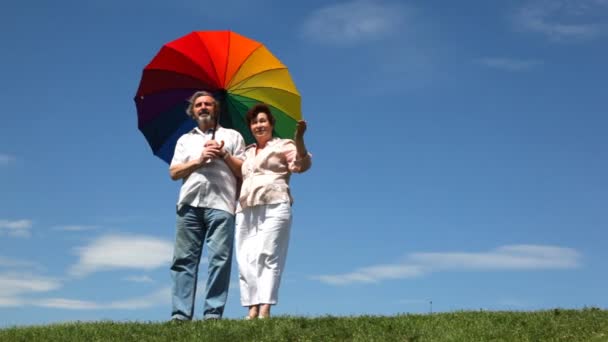 Couple se tient debout et parle avec parapluie tournant à son épaule — Video