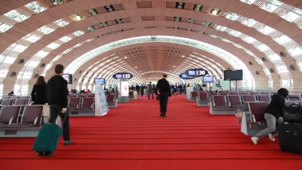 Personas con equipaje en la sala de espera en el aeropuerto Charles De Gaulle — Vídeos de Stock