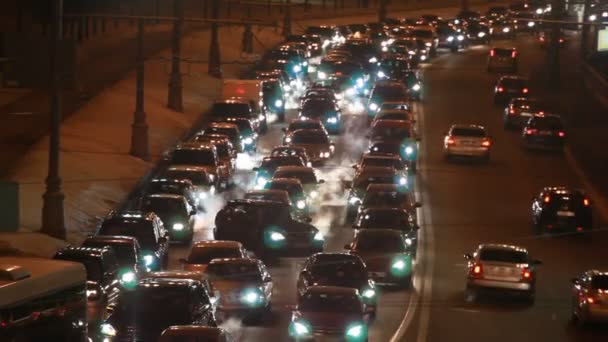 Carros em engarrafamento de tráfego duro na rua wintry da cidade à noite — Vídeo de Stock