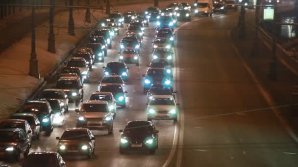汽车在硬交通果酱放在冬天的城市的街道在晚上 — 图库视频影像