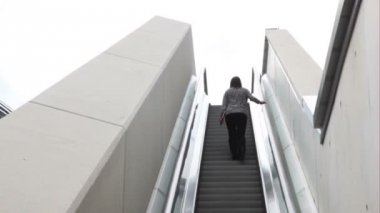 bir kadın tarafından yürüyen merdiven yukarı gidiyor.