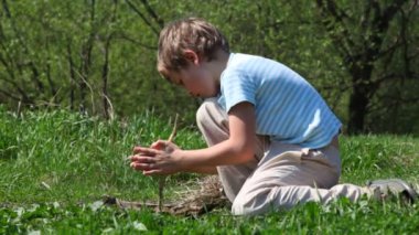 çocuğu sopayla ilkel arada alev almaya çalışır.