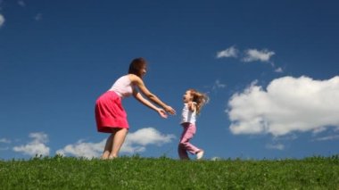 kadın kızıyla sahada oynuyor.