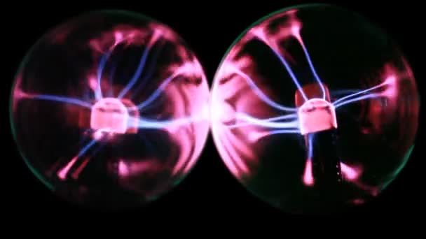 Two plasma balls stand close, energy lines move inside — Stock Video