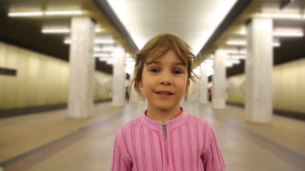 Dziewczynka stoi w pasażu metro, zbliżenie — Wideo stockowe