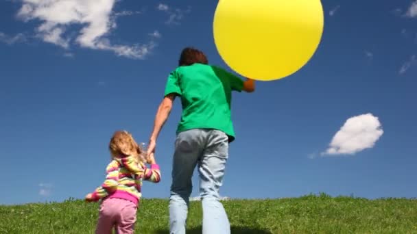 Father with daughter and bubble holding hands down hill — Stock Video