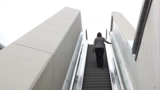 Seorang wanita akan ke atas oleh eskalator . — Stok Video