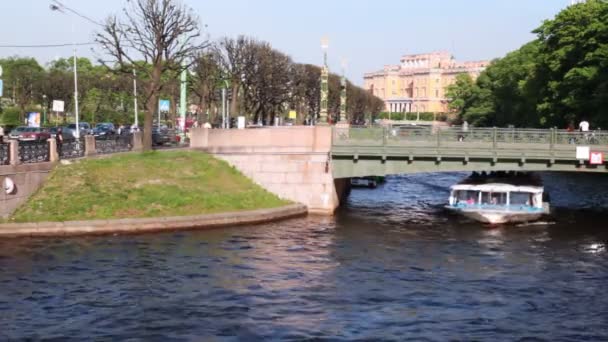 Лодка плавает под 2-м Садовым мостом через канал в центре Санкт-Петербурга — стоковое видео