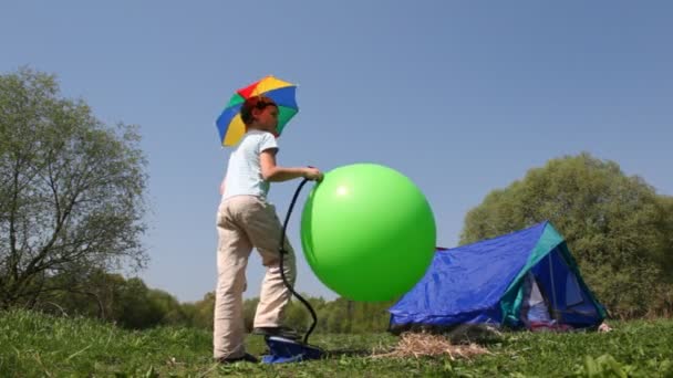 Мальчик качает мяч, девочка внутри палатки наводит порядок в лесу — стоковое видео