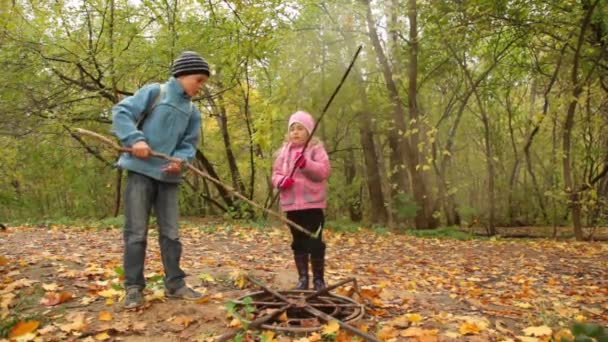 Les enfants cherchent quelque chose dans l'écoutille dans le parc . — Video