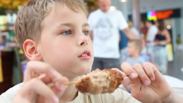 Caucásico chico comiendo shish kebab en café — Vídeos de Stock