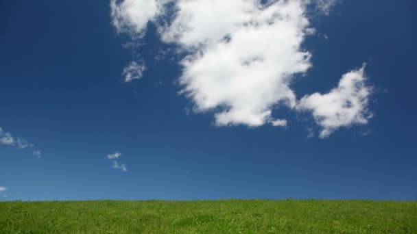 Nubes blancas se mueven a través del cielo por encima de colina verde, lapso de tiempo — Vídeos de Stock