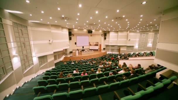 La gente se sienta en la sala de conferencias durante la presentación — Vídeos de Stock