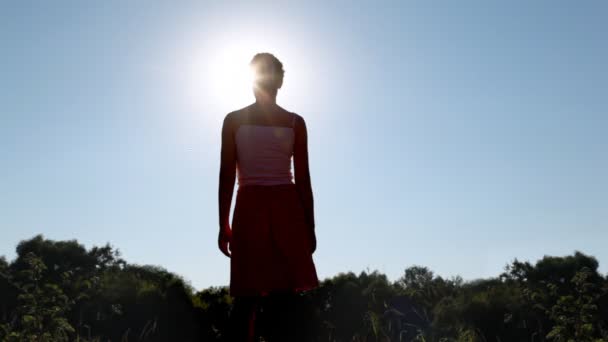 Silhouet van de vrouw permanent in zomer park — Stockvideo