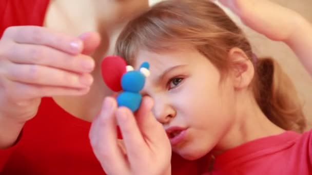 Femme sculpte figure d'éléphant de plasticine avec fille — Video