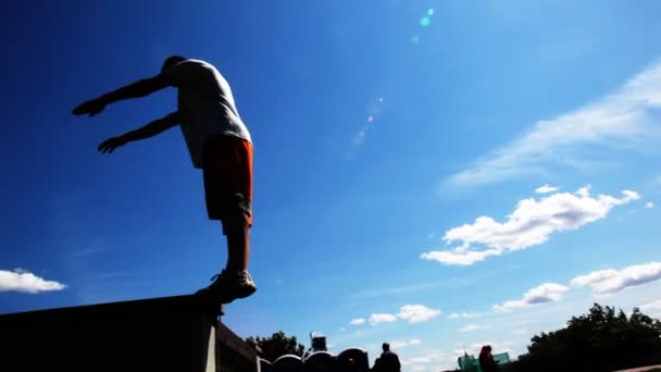 Мужчина делает сальто назад, спортсмен тренируется на открытом воздухе — стоковое видео
