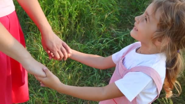 Girl and mother have joined hands in park — Stock Video