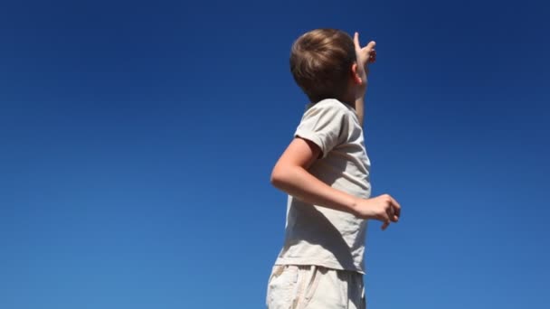 Boy turns, says and looks showing his hand up — Stock Video