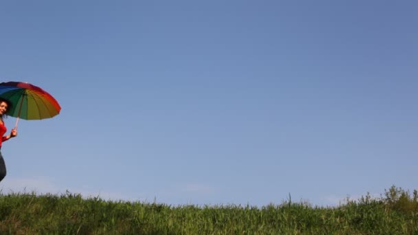 Moeder met paraplu en dochter lopen op gras — Stockvideo