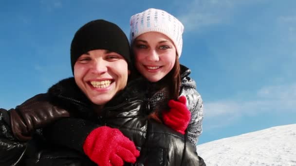 Chico y chica de pie al aire libre en invierno, ella lo abraza por detrás del cuello — Vídeos de Stock