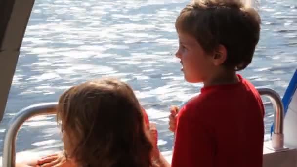 Αγόρι και η αδελφή του επιπλέουν γρήγορη κινούμενο σκάφος δελφίνι στη θάλασσα — Αρχείο Βίντεο
