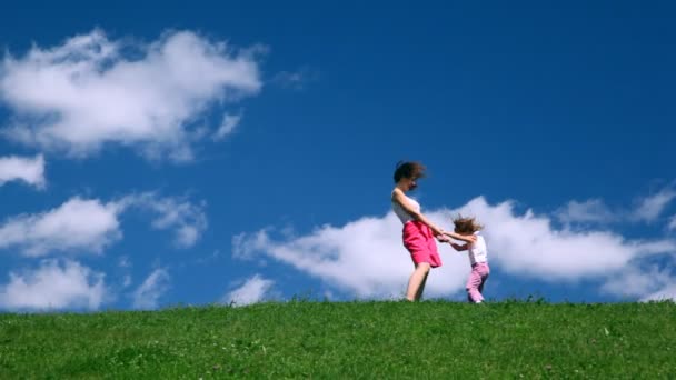 Kobieta z dziewczyna gra na wzgórzu — Wideo stockowe
