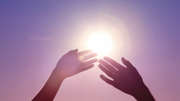 Geöffnete Handflächen von Mann und Frau, die sich gegen die Sonne berühren — Stockvideo