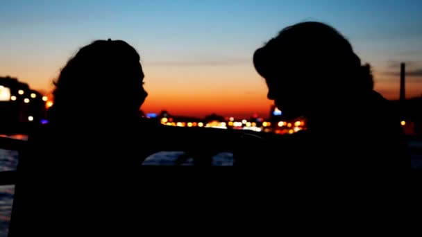 Silhouetten zweier Mädchen, die an Deck eines Segelschiffs sitzen und miteinander reden — Stockvideo