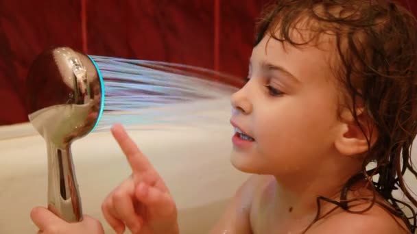 Дівчина грає у ванній кімнаті з світлодіодним світловим спреєм — стокове відео