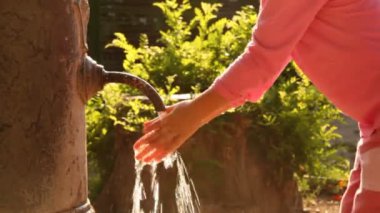 kadın eski paslı dokunun su akışı ellerini yıkar