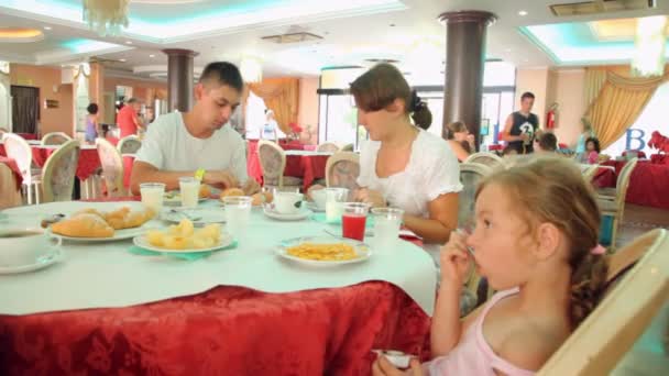 Familia de tres personas tiene desayuno en el comedor Hotel Club Bellerive — Vídeos de Stock