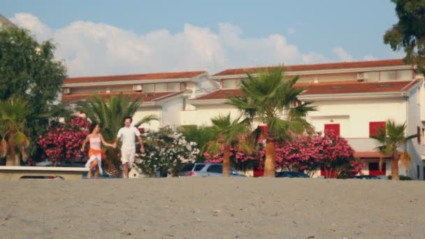 Pareja de amantes con brazos de sonrisa redonda smbs cintura y corre a la playa — Vídeo de stock