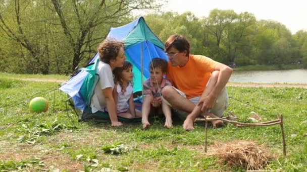 Familjen talar nära tält och boll i parken — Stockvideo