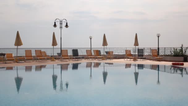 Paisagem de mar de piscina e chaise lounges lado — Vídeo de Stock