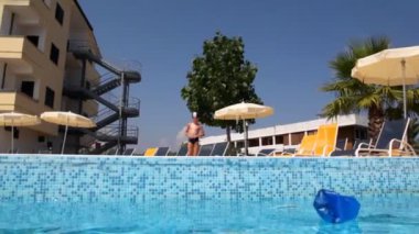 Yüzme şapkalı çocuk bıraktı çalışma ve kapalı burun havuza atladı