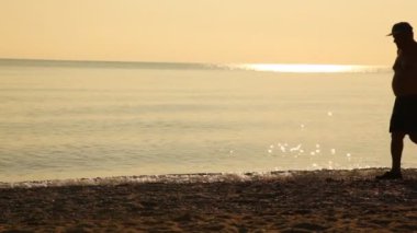 Sağdan sola deniz ve şapkalı bir adam geçti