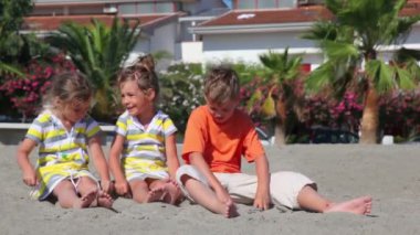 ağaç çocukların boy ve kum üzerine oturan iki kız