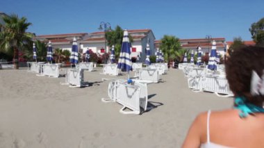 kadın runing çok şezlonglar arasında kum ile