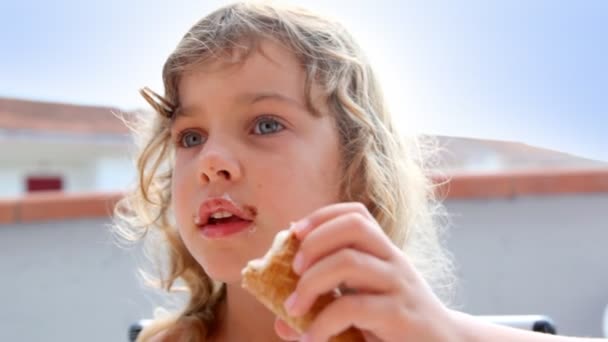 Маленькая девочка ест мороженое — стоковое видео
