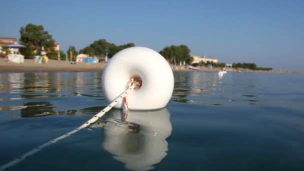 Eerste boei in lijn van boeien close-up op water — Stockvideo