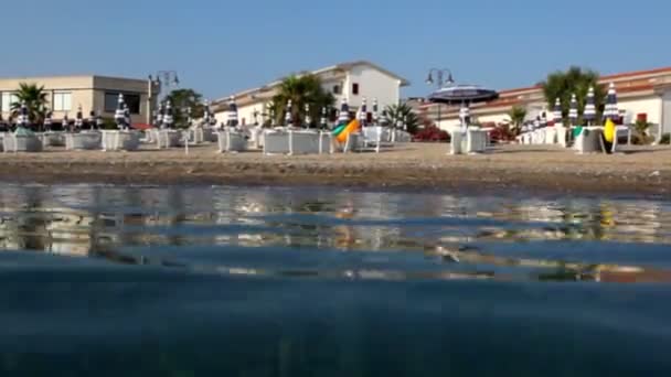 На пляже отеля от воды и камеры на поверхности воды — стоковое видео