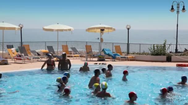 Tourists make waterobics in pool near beach — Stock Video